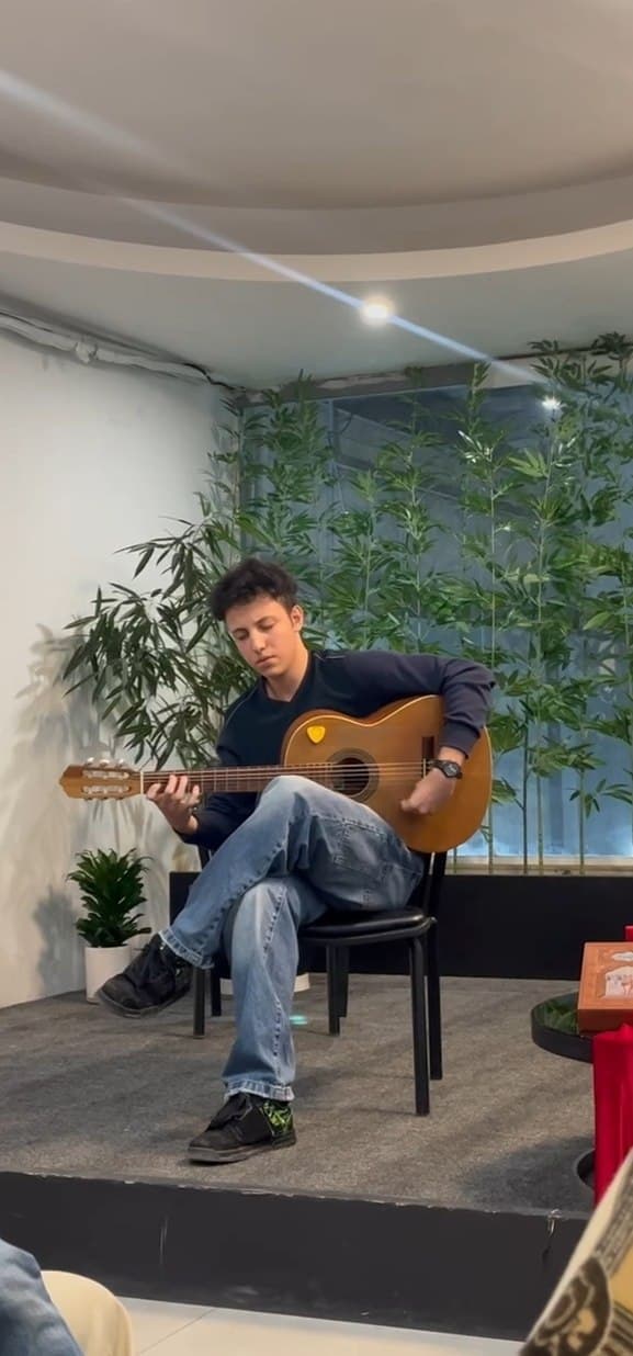 A guitarist performing on a nylon-string Spanish guitar